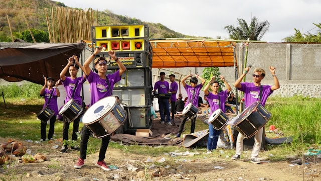 Group flow: Musicians outisde, wearing purple outfits.